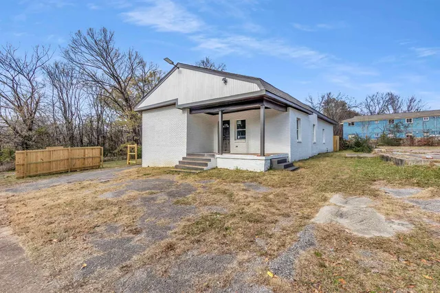 a view of a house with backyard and trees