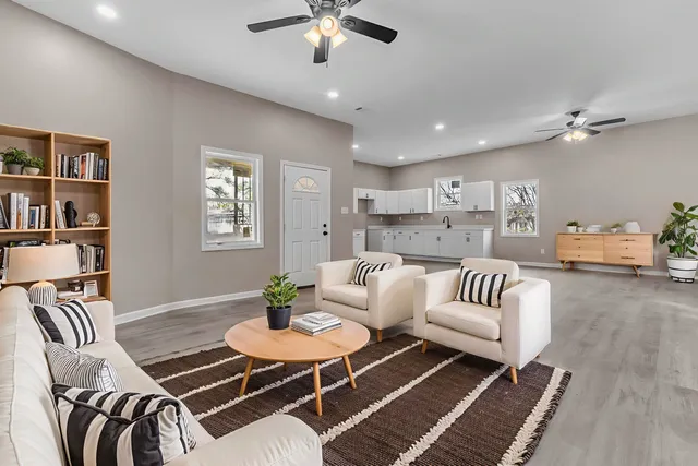 an empty room with windows and fan