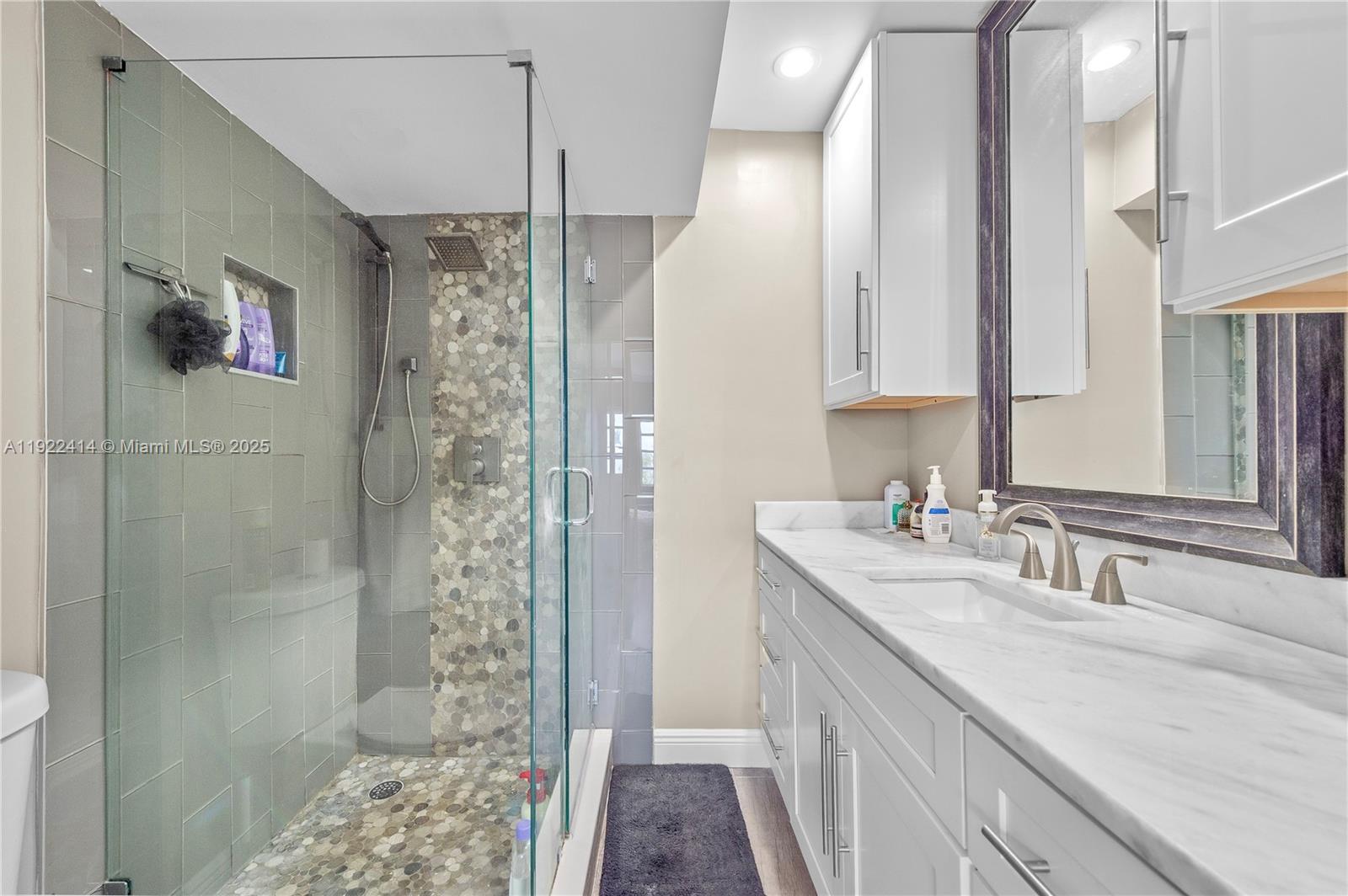 900 Southwest 12th Street, Unit 206 Fort Lauderdale, FL 33315 - Photo 12 of 24 a bathroom with a double vanity sink a large mirror and shower