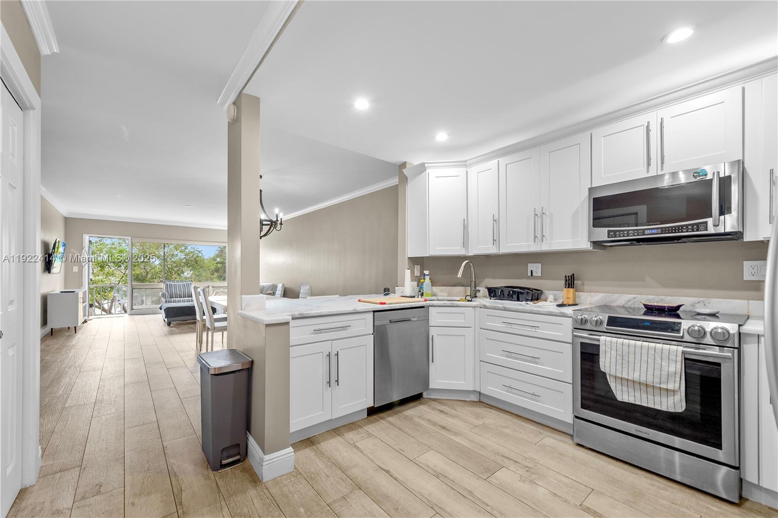 900 Southwest 12th Street, Unit 206 Fort Lauderdale, FL 33315 - Photo 2 of 24 a kitchen with a stove top oven sink and cabinets