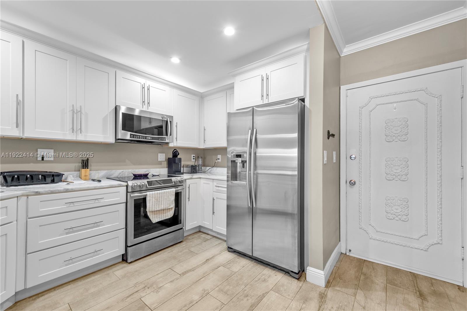 900 Southwest 12th Street, Unit 206 Fort Lauderdale, FL 33315 - Photo 3 of 24 a kitchen with stainless steel appliances granite countertop a refrigerator sink and white cabinets