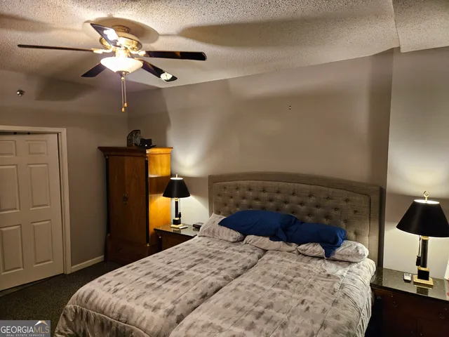 a bedroom with a bed and a lamp on dresser