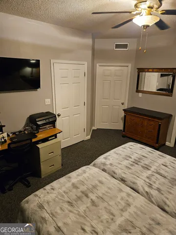 a bedroom with a bed and a flat tv screen on a dresser