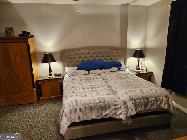 a bedroom with a bed and a flat tv screen on the dresser