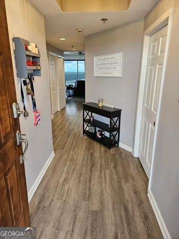 a view of a hallway with wooden floor and stairs