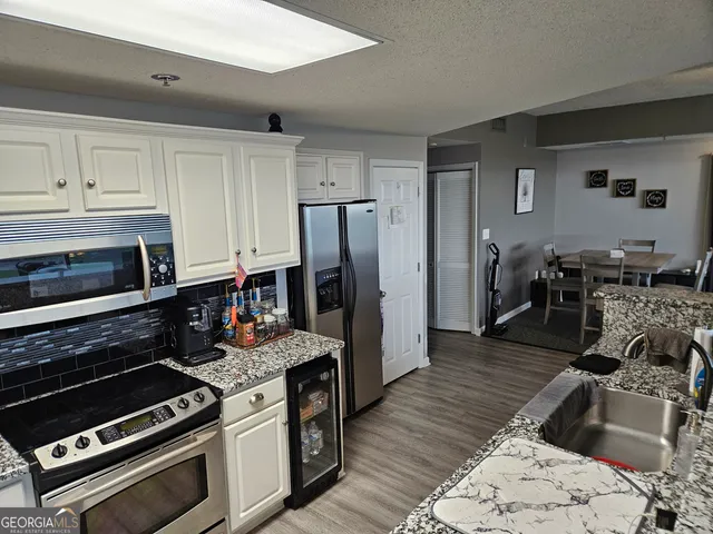a kitchen with granite countertop a stove and a refrigerator