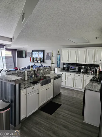 a large kitchen with stainless steel appliances kitchen island granite countertop a sink and cabinets