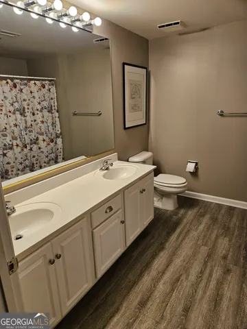 a spacious bathroom with a double vanity sink toilet and a mirror