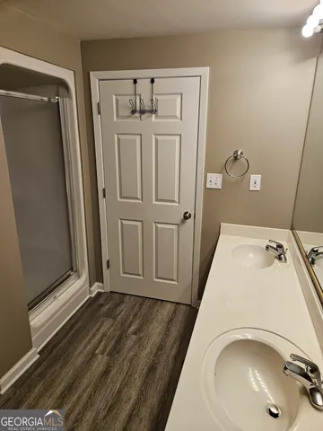 a bathroom with a sink and glass door shower