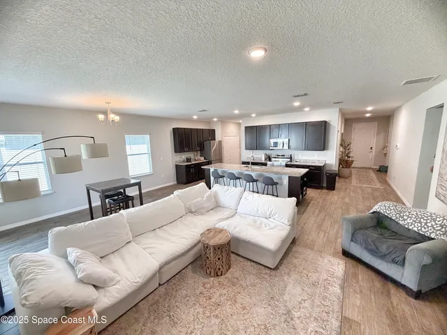 a living room with furniture and kitchen view