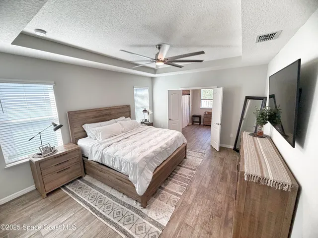 a spacious bedroom with a bed and a flat screen tv