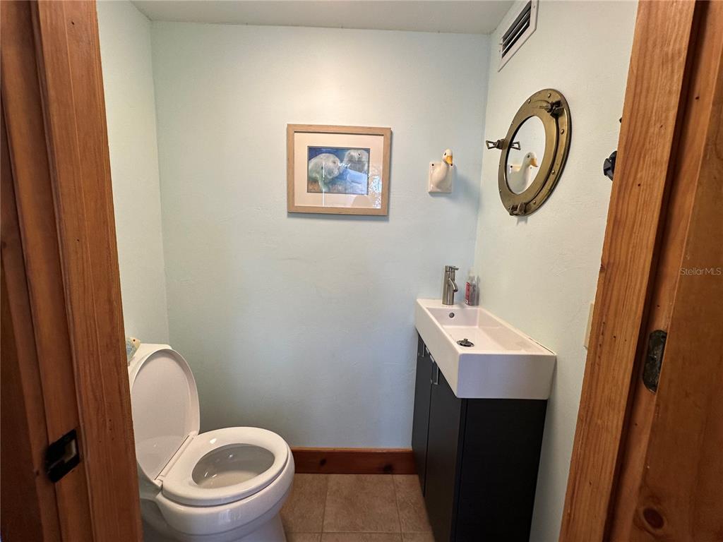 56315 Hickory Road Astor, FL 32102 - Photo 17 of 31 a bathroom with a toilet a sink and mirror
