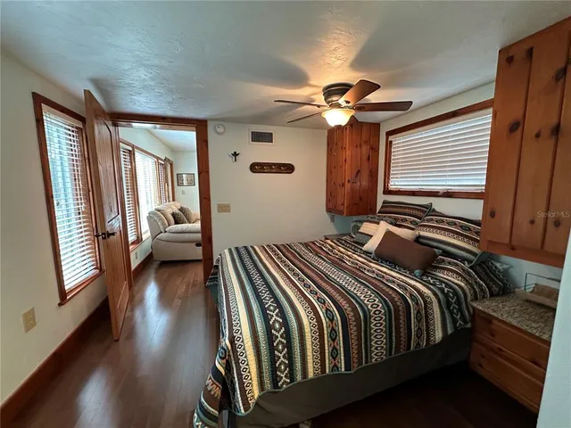 a bedroom with a bed large mirror and a large window