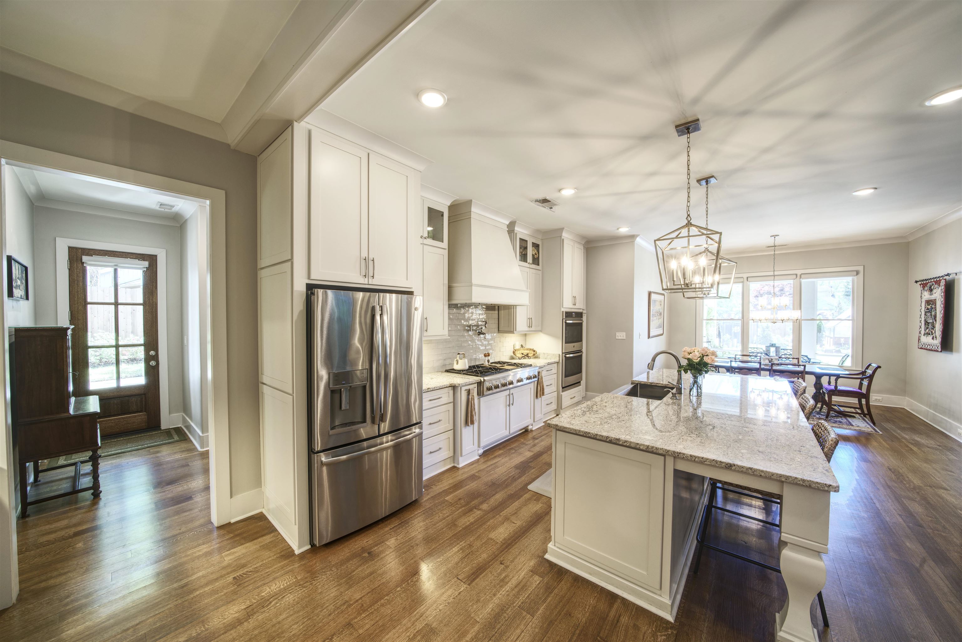 5293 Cole Road Memphis, TN 38120 - Photo 17 of 40 a kitchen with a center island wooden floor and stainless steel appliances