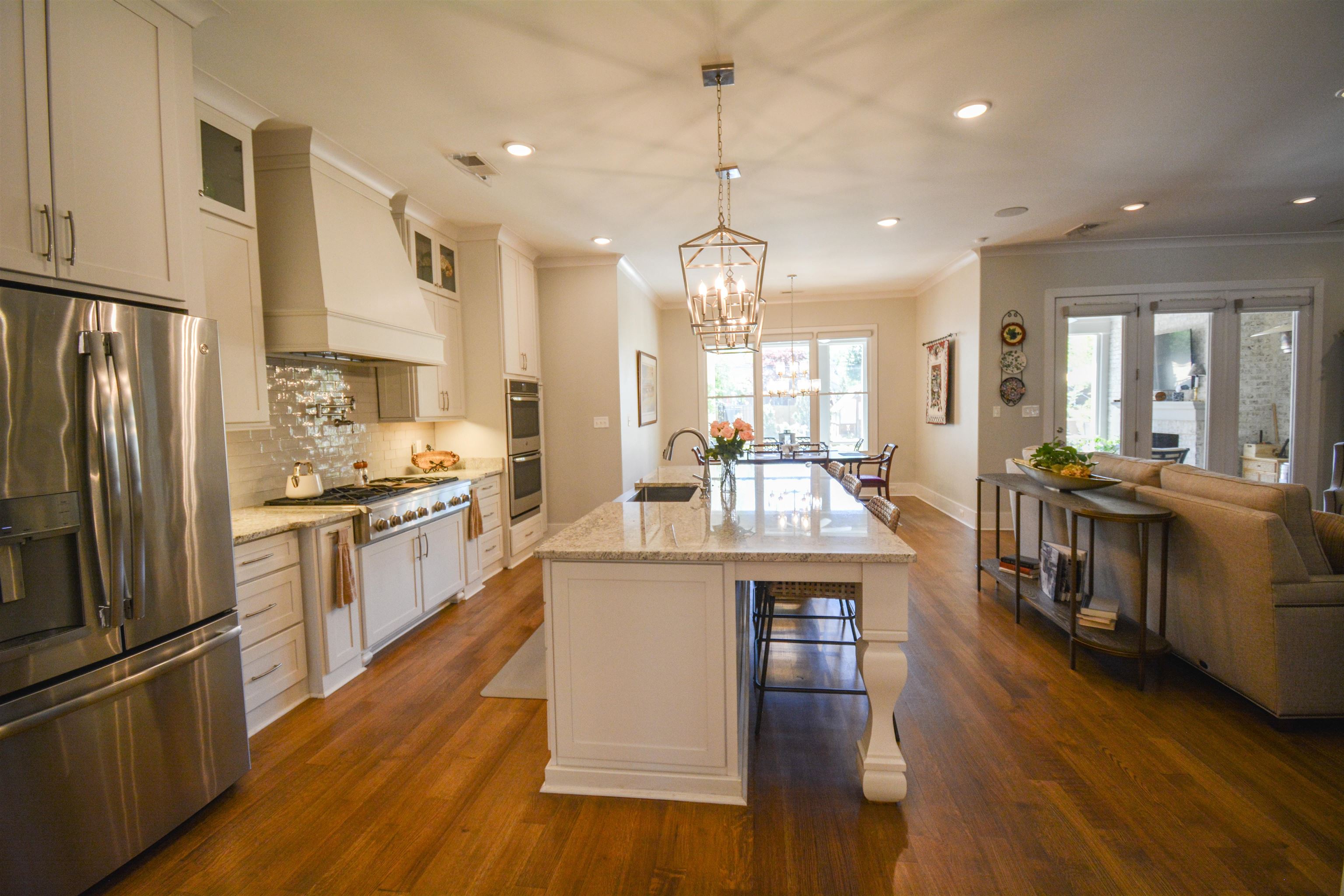 5293 Cole Road Memphis, TN 38120 - Photo 18 of 40 a kitchen with stainless steel appliances granite countertop a refrigerator a stove top oven a sink dishwasher and a dining table with wooden floor