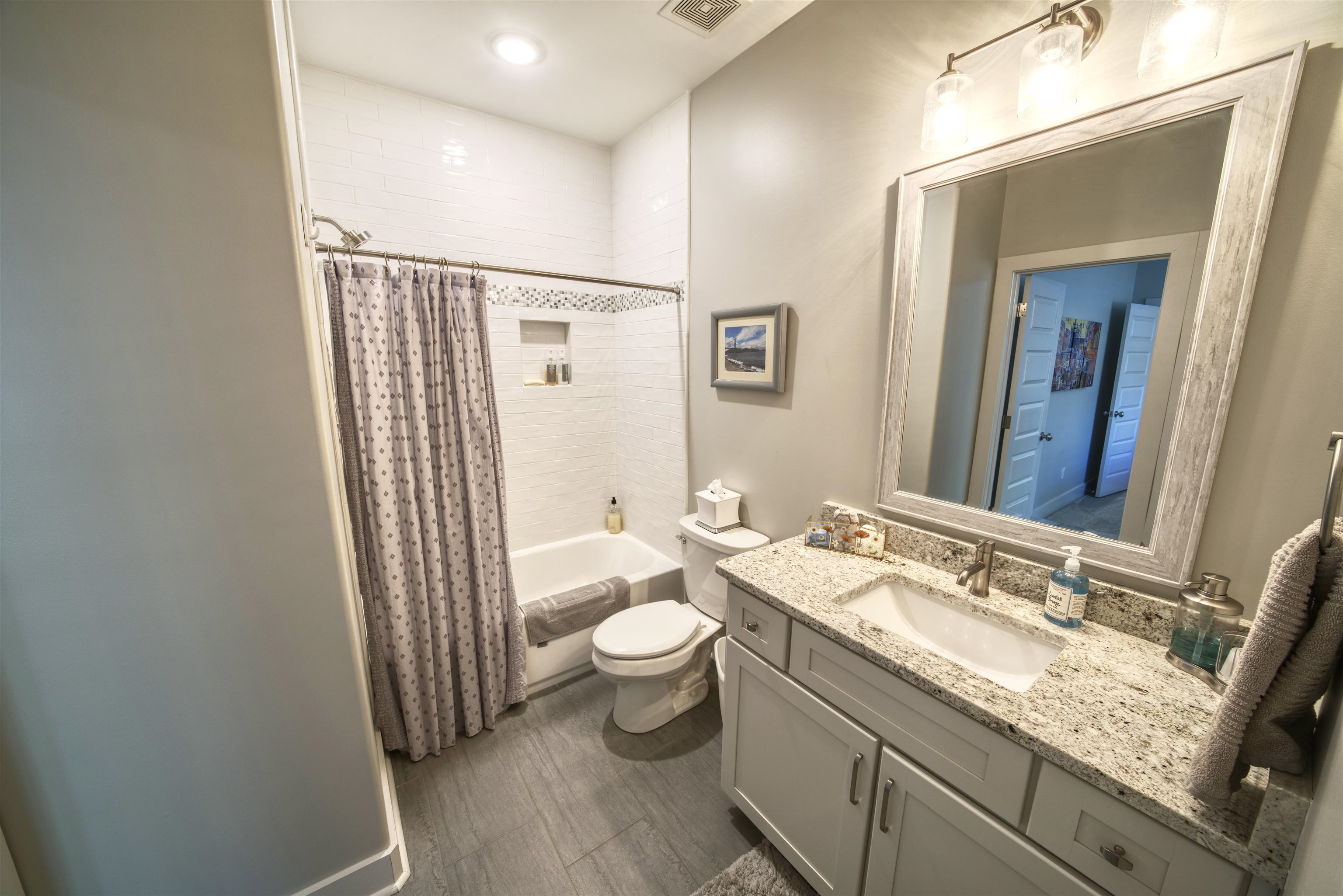 5293 Cole Road Memphis, TN 38120 - Photo 26 of 40 a bathroom with a granite countertop sink a toilet and a mirror