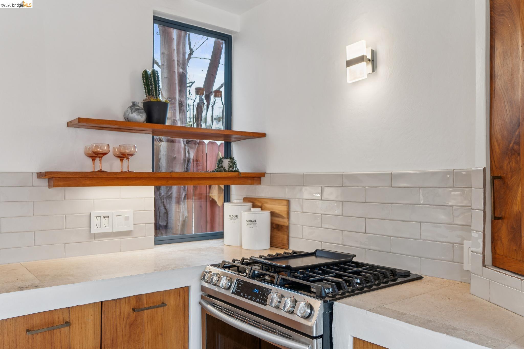 2015 Delaware Street Berkeley, CA 94709 - Photo 11 of 60 Kitchen with open shelves, stainless steel range with gas stovetop, light countertops, and wood finish cabinetry