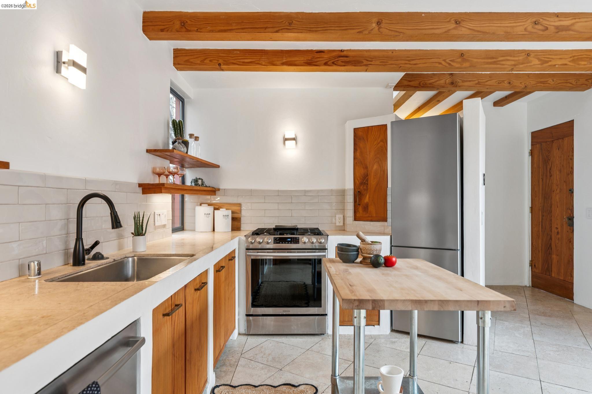 2015 Delaware Street Berkeley, CA 94709 - Photo 16 of 60 Kitchen with light countertops, stainless steel appliances, wood finish cabinets, open shelves, and decorative backsplash