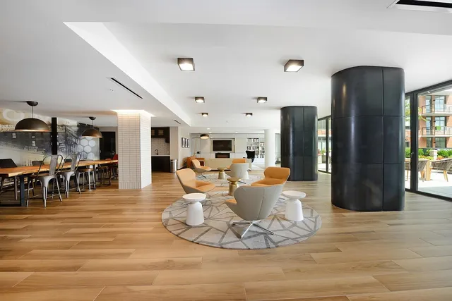 a living room with lots of furniture and a view of dining hall with wooden floor