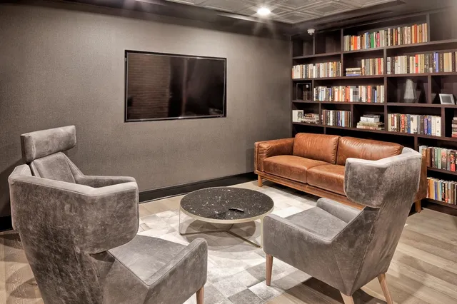 a living room with furniture a rug and a book shelf