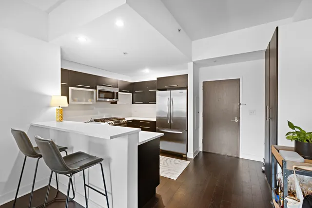 a kitchen that has a kitchen island wooden cabinets and stainless steel appliances