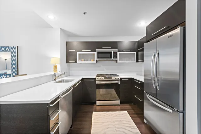a kitchen with granite countertop a refrigerator and a sink