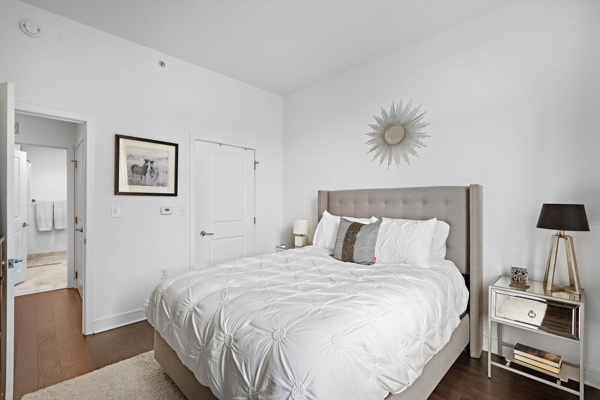 1450 Washington Street, Unit 609 Hoboken, NJ 07030 - Photo 8 of 30 a bedroom with a bed and a chandelier