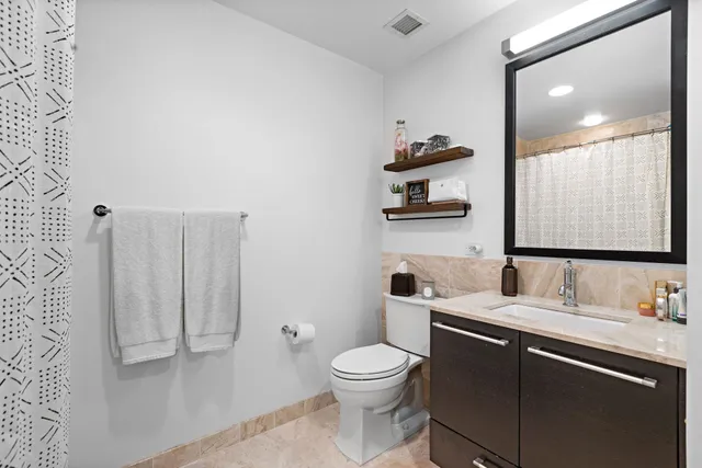 a bathroom with a toilet a sink and mirror