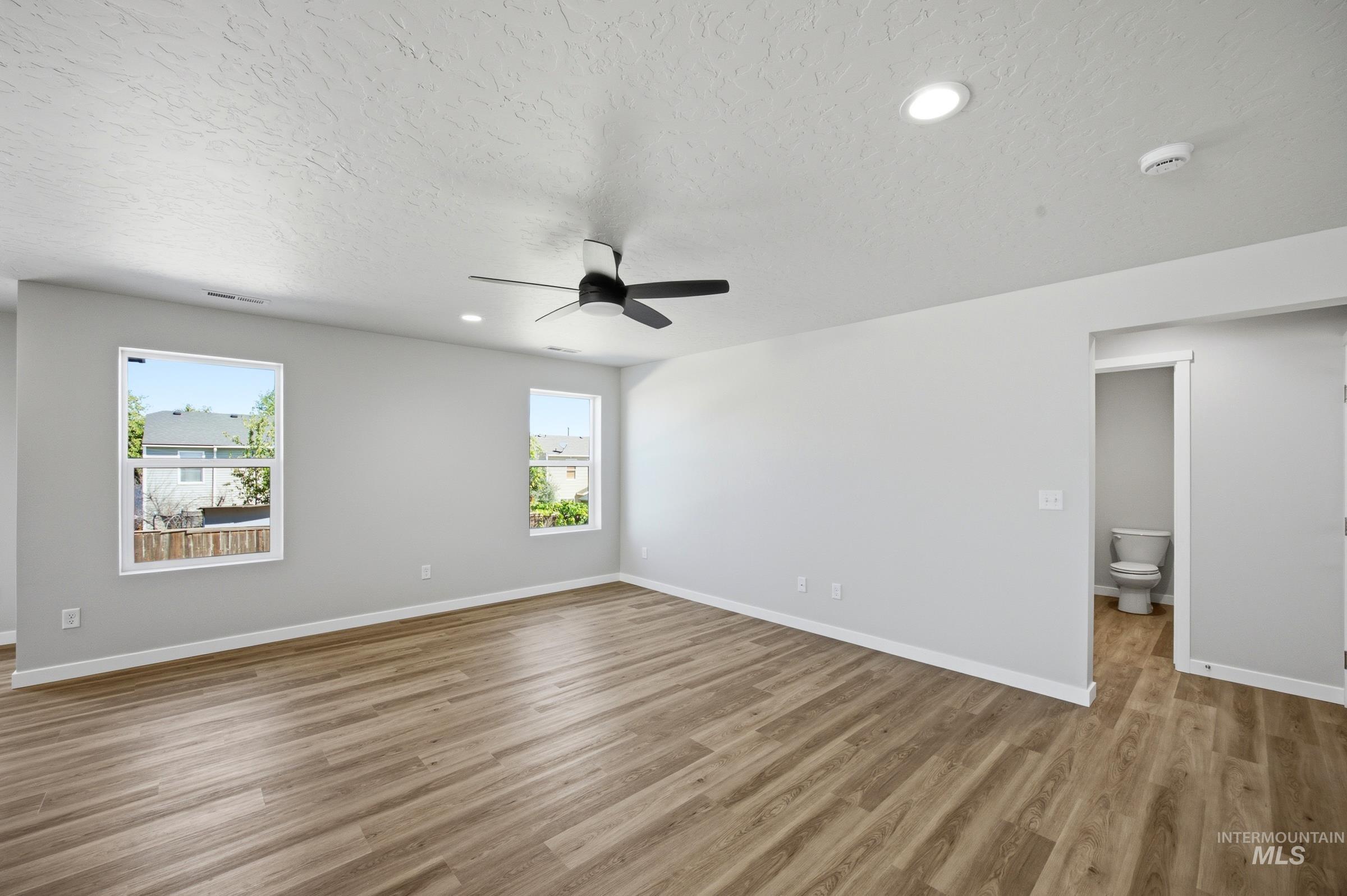 13333 Bank Street Caldwell, ID 83607 - Photo 5 of 29 Spacious room with wood-finish flooring, two windows, recessed lighting, and a ceiling fan