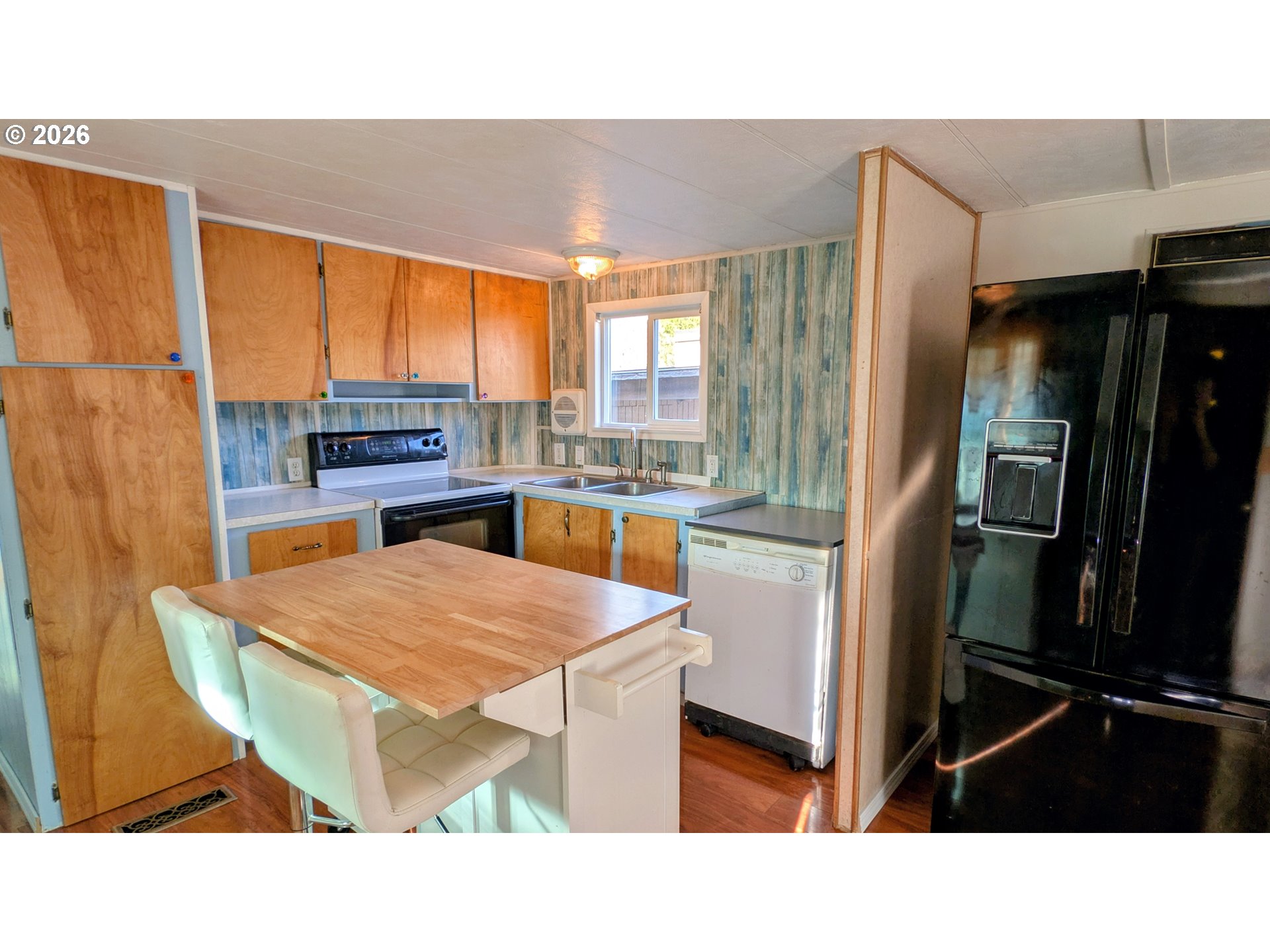 3203 Southeast Vineyard Road, Unit 12 Milwaukie, OR 97267 - Photo 9 of 20 a kitchen with a table chairs and refrigerator