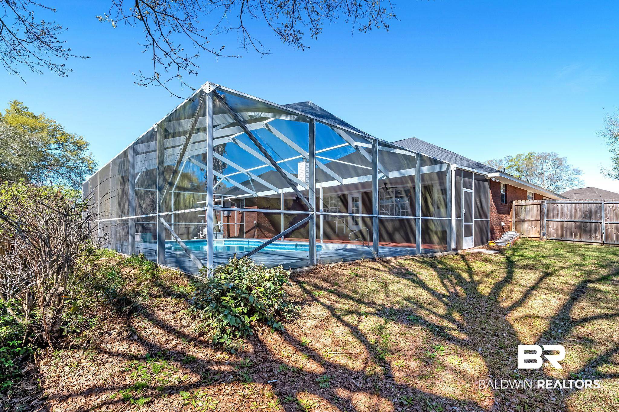 16444 Hamlet Lane Foley, AL 36535 - Photo 4 of 49 Rear view of property featuring glass enclosure, fence, a fenced in pool, and a yard