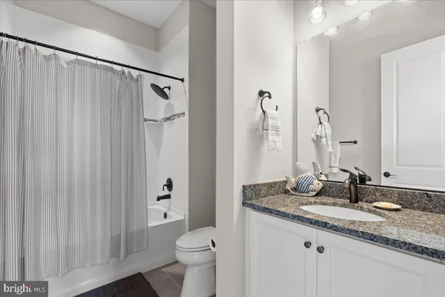 a dining room with stainless steel appliances kitchen island granite countertop a table chairs and a living room view