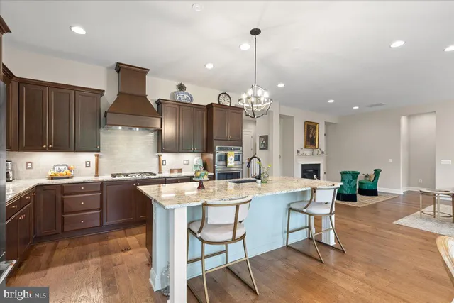a view of an empty room with wooden floor and a fireplace