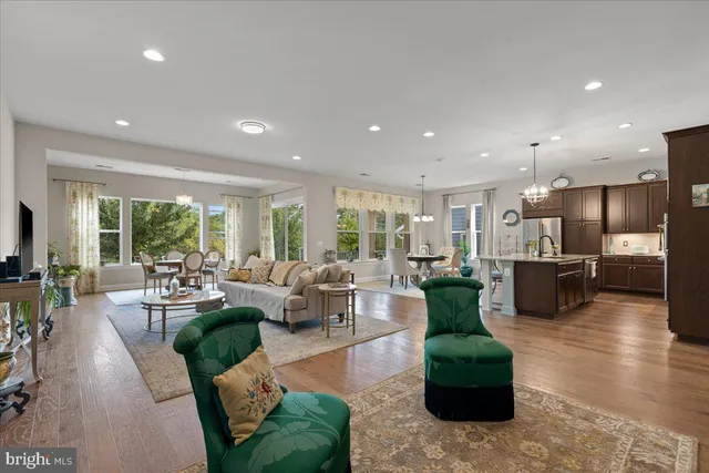 a living room with furniture kitchen view and a large window