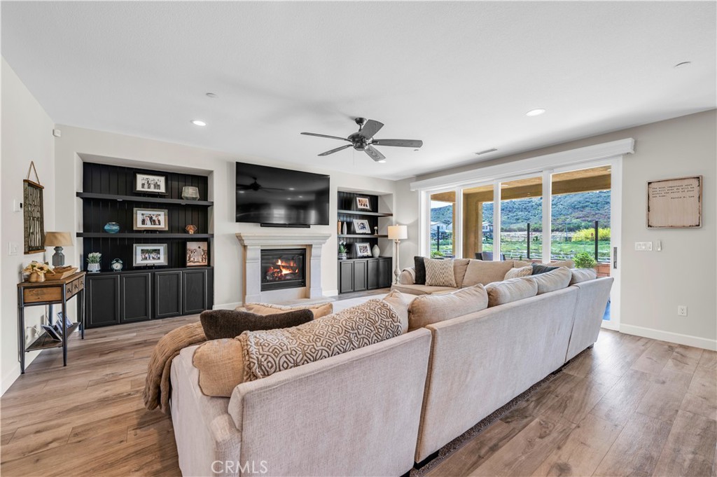 33303 Barmetta Lane Temecula, CA 92592 - Photo 15 of 46 a living room with furniture a flat screen tv and a fireplace