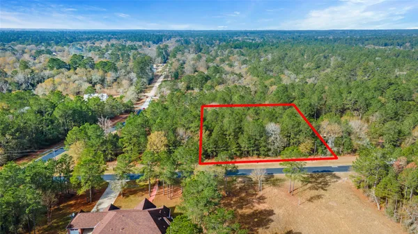 a view of a field with plants and wooden fence