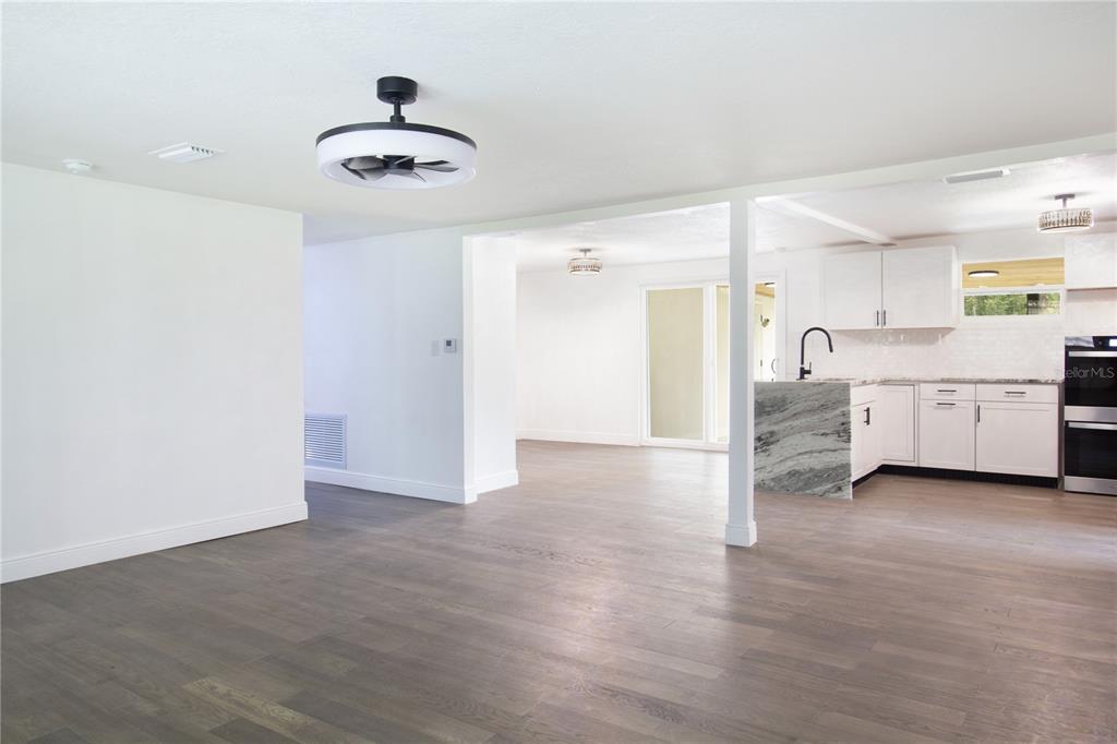 39912 Jerry Road Zephyrhills, FL 33540 - Photo 11 of 59 a view of a kitchen with a refrigerator a ceiling fan and wooden floor