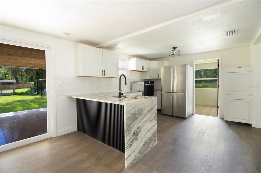 39912 Jerry Road Zephyrhills, FL 33540 - Photo 13 of 59 a kitchen with stainless steel appliances granite countertop a refrigerator and a sink