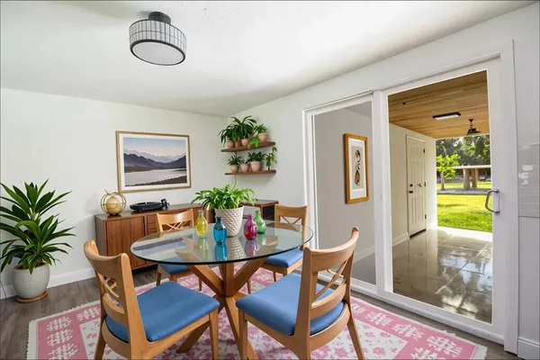 an empty room with ceiling fan and windows