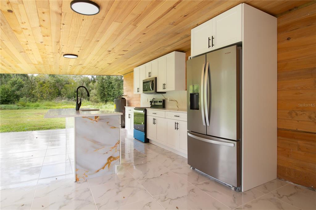 39912 Jerry Road Zephyrhills, FL 33540 - Photo 43 of 59 a kitchen with stainless steel appliances granite countertop a refrigerator a stove and a sink with garden