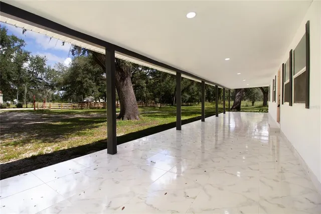 an empty room with windows and fireplace