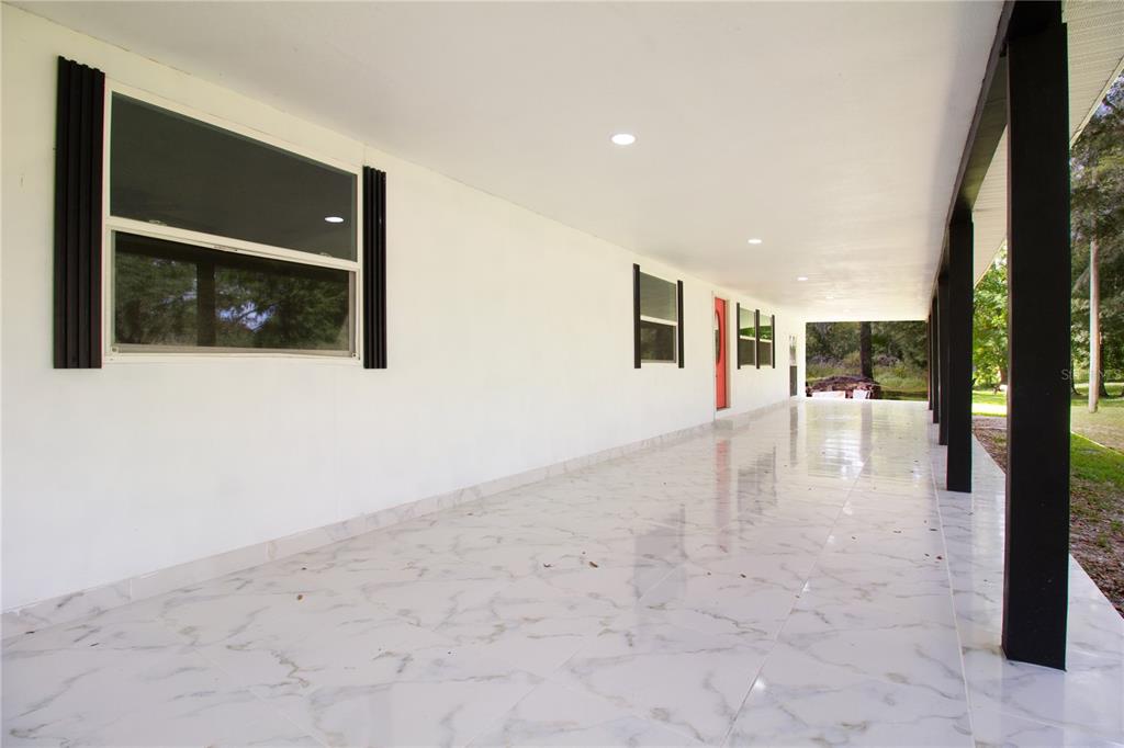 39912 Jerry Road Zephyrhills, FL 33540 - Photo 6 of 59 a view of a hallway with wooden floor and a living room