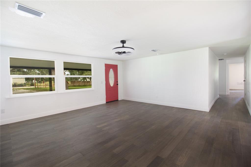 39912 Jerry Road Zephyrhills, FL 33540 - Photo 9 of 59 an empty room with windows and ceiling fan