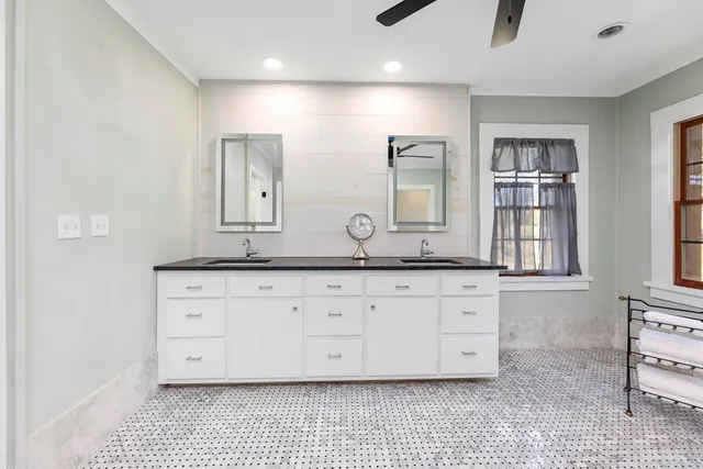 an empty room with windows and chandelier fan