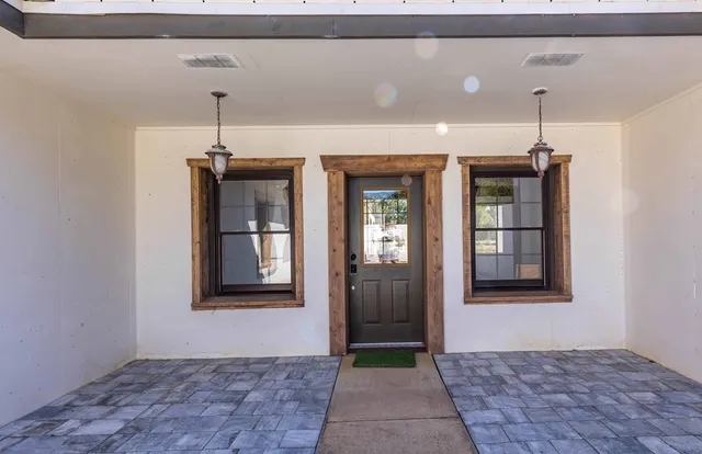 a view of a bedroom with furniture large windows and wooden floor