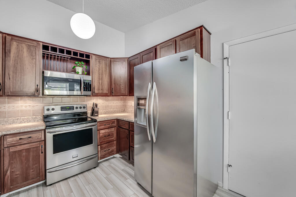 23428 Country Club Drive East Boca Raton, FL 33428 - Photo 15 of 32 a kitchen with stainless steel appliances a refrigerator sink and cabinets