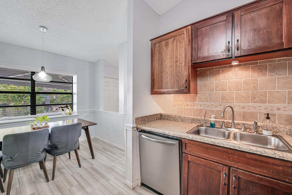 23428 Country Club Drive East Boca Raton, FL 33428 - Photo 16 of 32 a kitchen with a sink cabinets and wooden floor