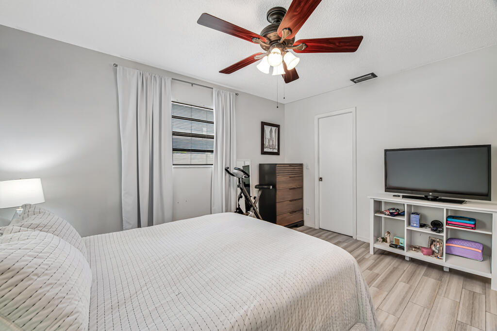 23428 Country Club Drive East Boca Raton, FL 33428 - Photo 20 of 32 a bedroom with a bed and a flat screen tv