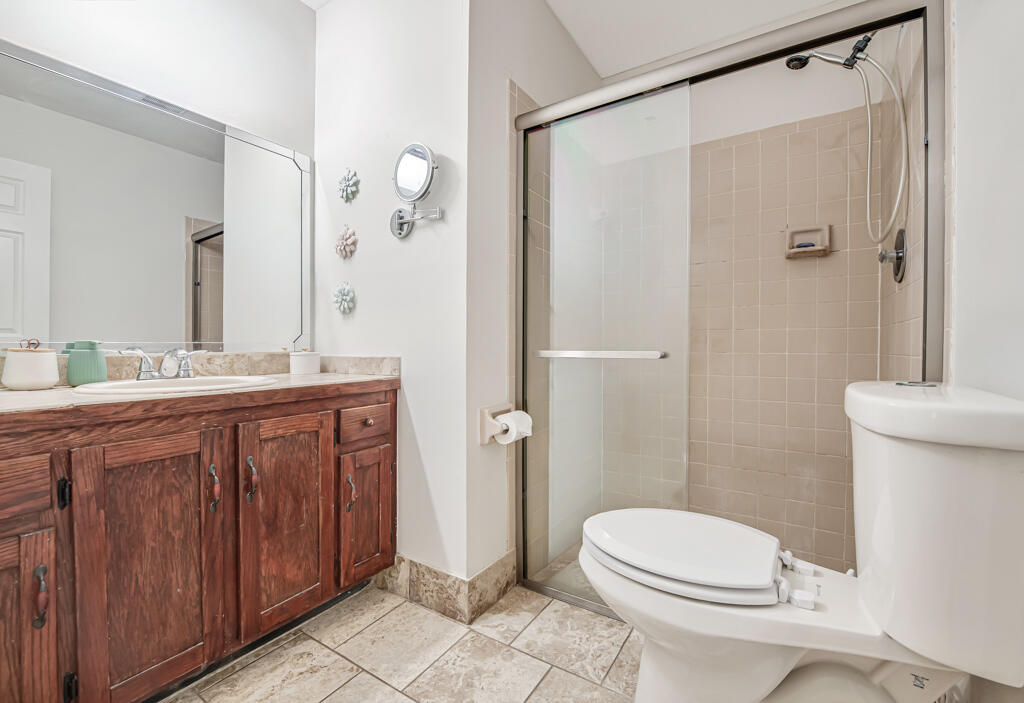 23428 Country Club Drive East Boca Raton, FL 33428 - Photo 21 of 32 a bathroom with a granite countertop sink toilet and shower