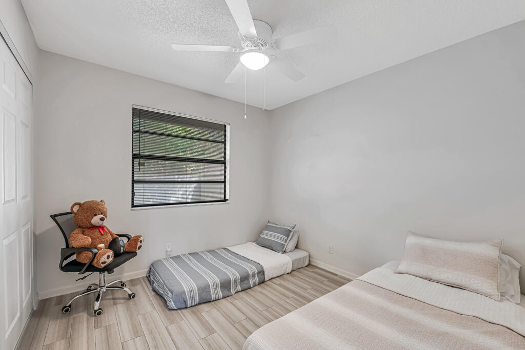 23428 Country Club Drive East Boca Raton, FL 33428 - Photo 22 of 32 a bedroom with a bed and a chair